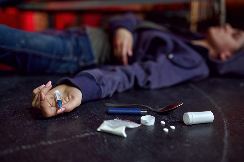 Drug addict man lying on the floor, overdose