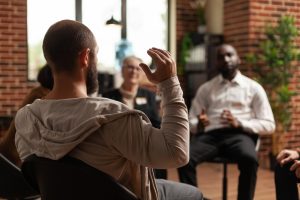 Men at an AA meeting talking about their addictions and recovery at Design for Recovery sober living homes for men in Los Angeles